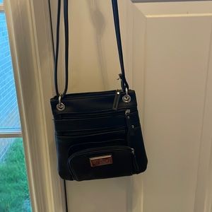 Is a Nicole Miller Purse it’s black cute it has five pocket has a Lotta room
